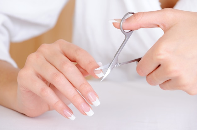 Free photo female cutting nail on the  index finger