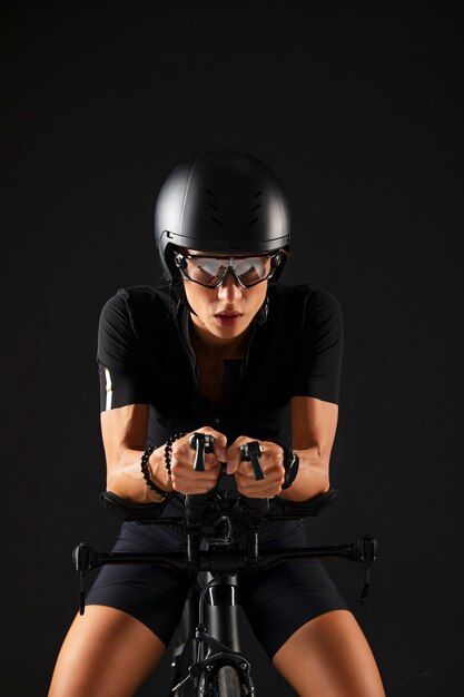 Female cyclist posing with bicycle and helmet