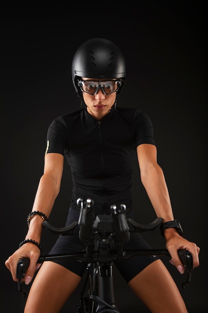 Female cyclist posing with bicycle and helmet