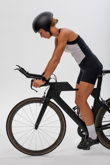 Free photo female cyclist posing with helmet and bicycle