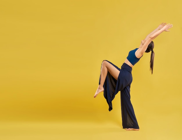 Female dancer in wide pants performing dance poses outdoors