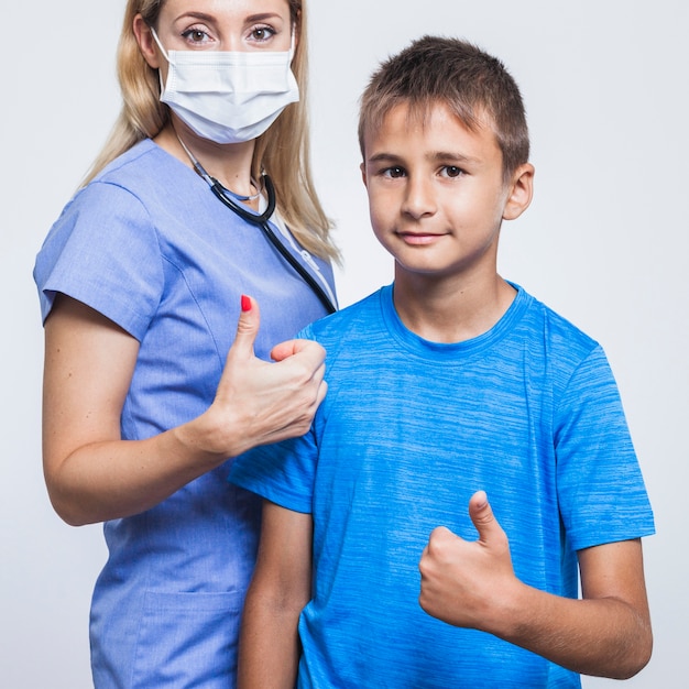 Female dentist and boy gesturing thumbs up