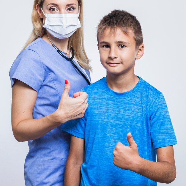 Female dentist and boy gesturing thumbs up