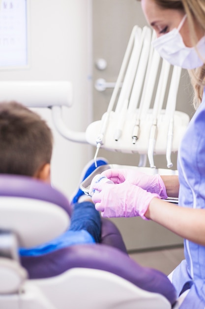 Free photo female dentist looking at teeth plaster mold in clinic