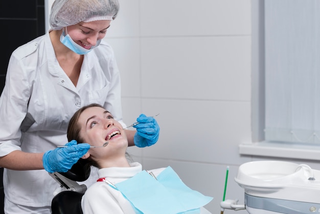 患者の歯科検査を行う女性歯科医