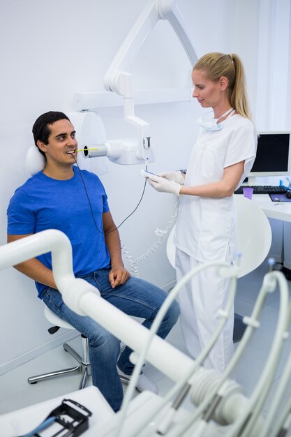 Female dentist taking x-ray of patients teeth