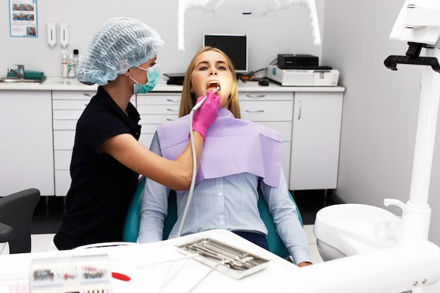 그녀의 환자 치아를 치료하는 여성 치과 의사