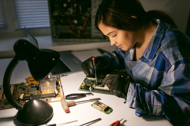 female at desk repairing 