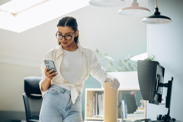 Female digital designer talking on the phone in an office