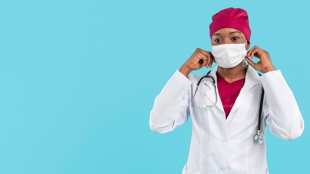 Free photo female doctor adjusting her surgeon mask