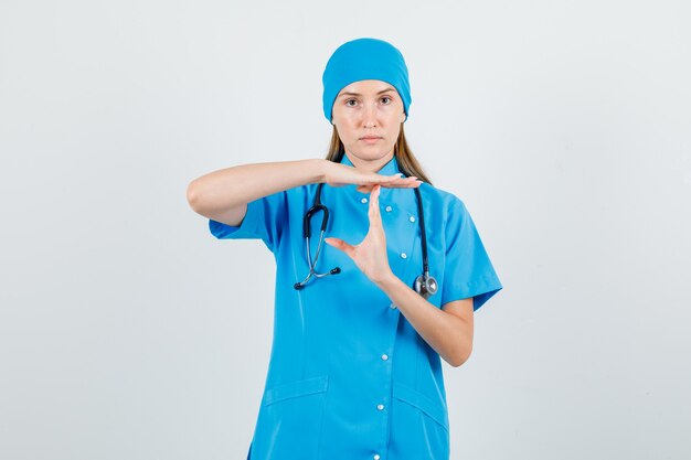 Female doctor in blue uniform doing time break gesture and looking strict