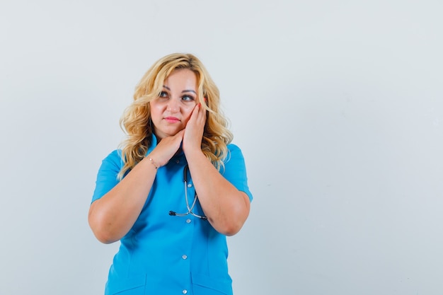 Female doctor in blue uniform making pillow gesture