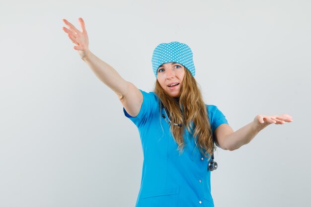 Female doctor in blue uniform opening arms for hug and looking joyful 