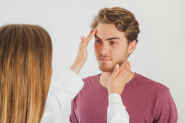 Foto gratuita medico femminile controllare il viso del paziente