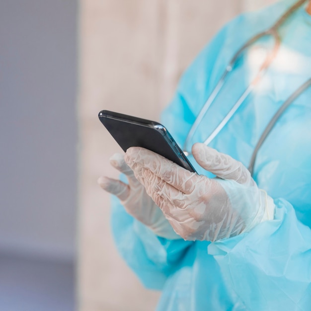Бесплатное фото Женщина-врач проверяет ее телефон крупным планом