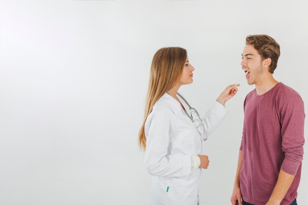 Female doctor checking mouth of patient