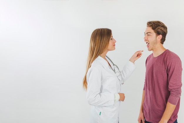Female doctor checking mouth of patient