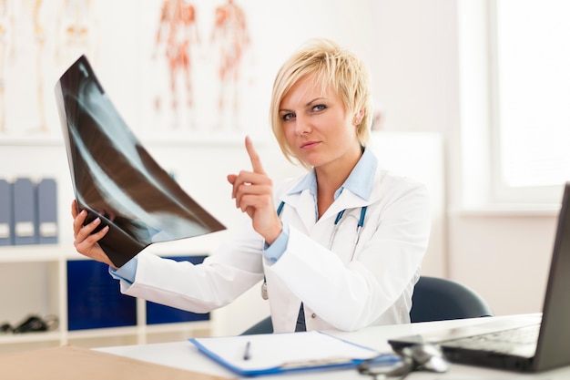 Free photo female doctor checking x ray image