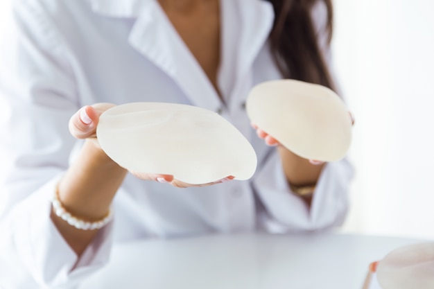 Free photo female doctor choosing mammary prosthesis in the office.