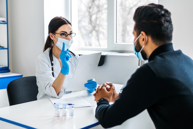 A female doctor consults her patient and holds documents in her hands