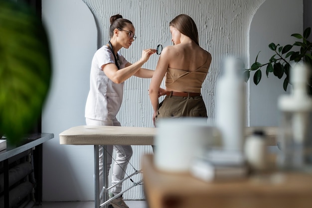 Free photo female doctor diagnosing a melanoma on the body of a female patient