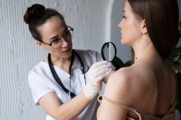 Female doctor diagnosing a melanoma on the body of a female patient