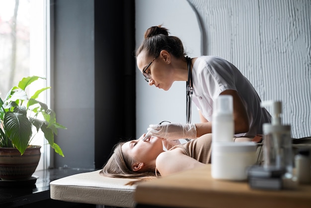 Free photo female doctor diagnosing a melanoma on the body of a female patient