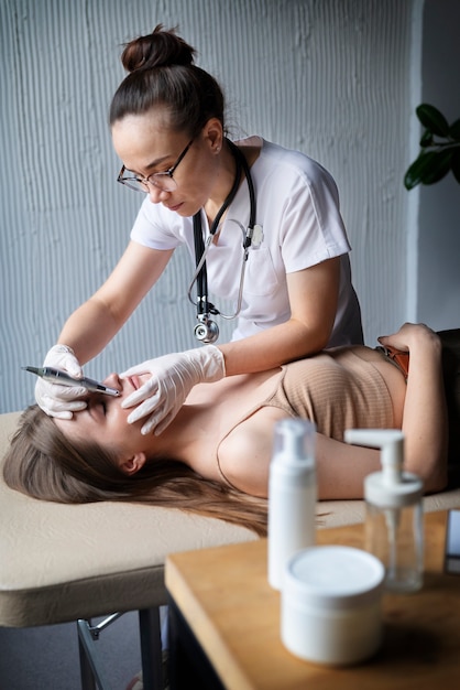 Female doctor diagnosing a melanoma on the body of a female patient