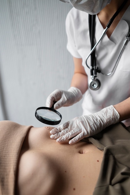 Female doctor diagnosing a melanoma on the body of a female patient