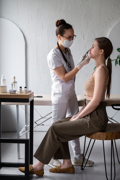 Female doctor diagnosing a melanoma on the body of a female patient