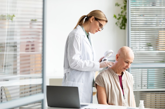 Foto gratuita medico donna che fa un controllo su un paziente con cancro della pelle