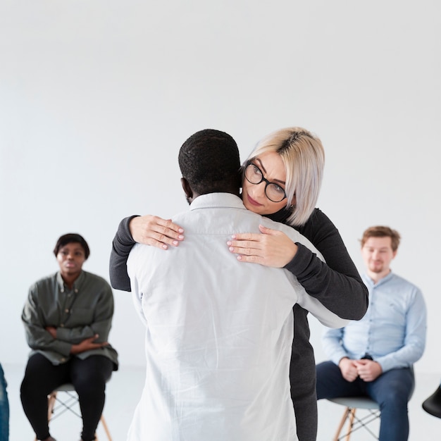 Female doctor embracing afro-american patient