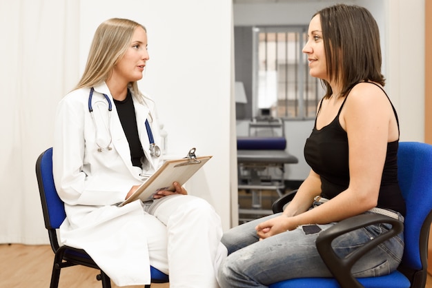 Female doctor explaining diagnosis to her young woman patient.