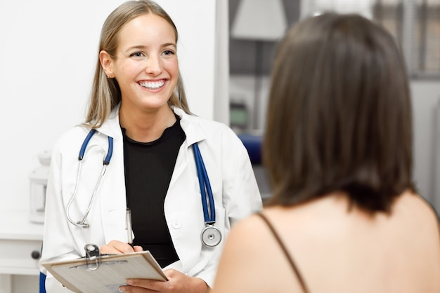 Female doctor explaining diagnosis to her young woman patient.