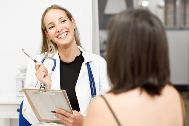 Female doctor explaining diagnosis to her young woman patient.