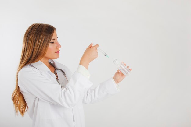 Female doctor filling liquid in needle