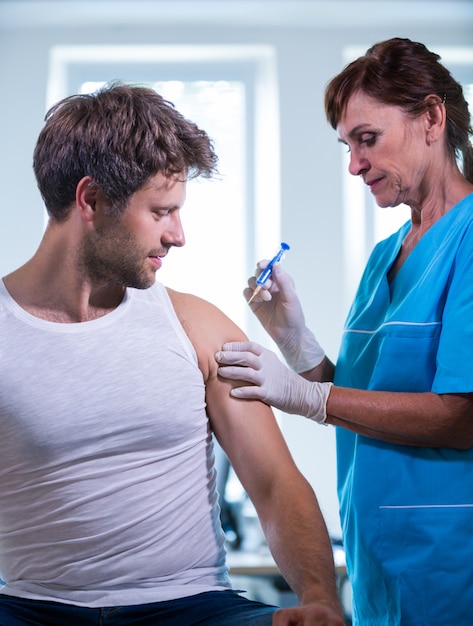 Free photo female doctor giving an injection to a patient