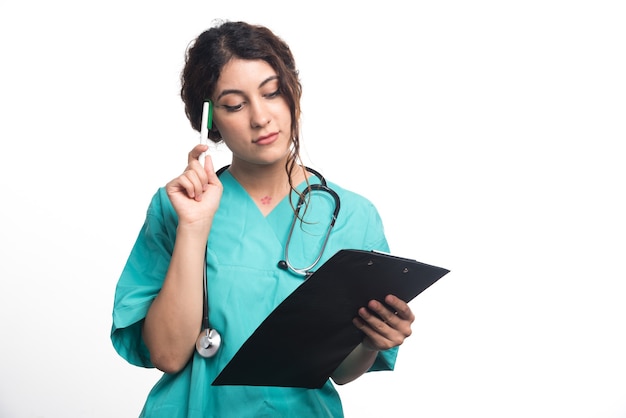 Женщина-врач, держа в руках черный буфер обмена на белом фоне. Фото высокого качества