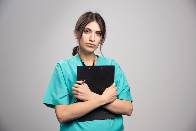 Female doctor holding clipboard tightly