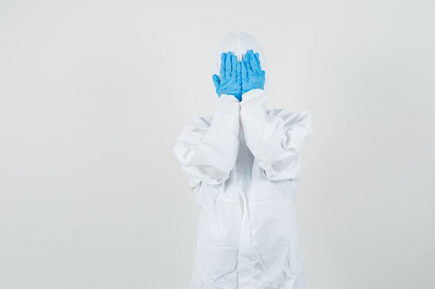 Female doctor holding hands on face in protective suit