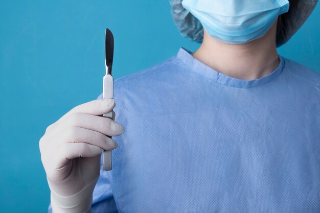 Female doctor holding metallic medical scalpel