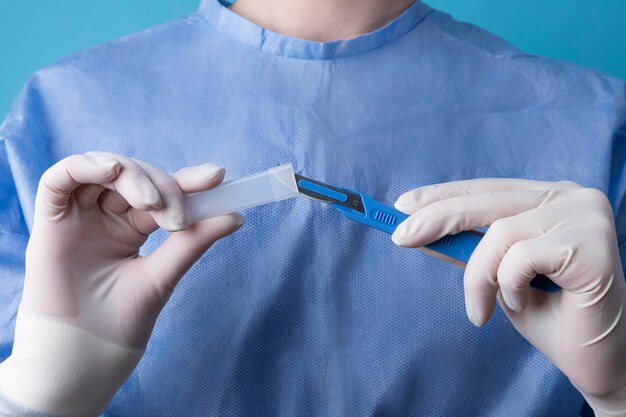 Female doctor holding metallic medical scalpel