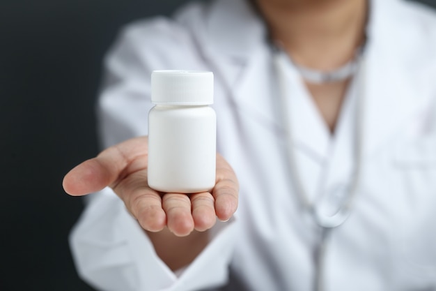 Free photo female doctor holding and showing a medicine bottle