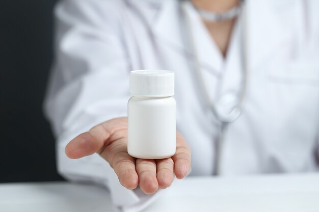 female doctor holding and showing a medicine bottle