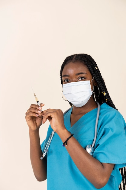 Foto gratuita medico femminile che tiene la siringa con il vaccino