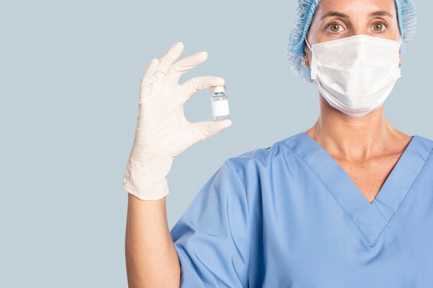 Free photo female doctor holding a vaccine bottle