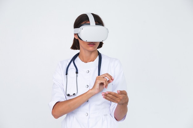 白衣を着た女性医師が孤立し、仮想現実の眼鏡をかけて空気に触れる