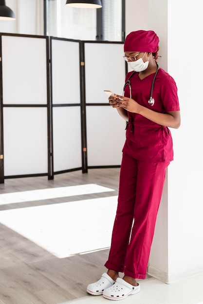 Female doctor leaning on a wall