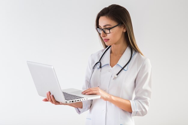 Female doctor looking on laptop