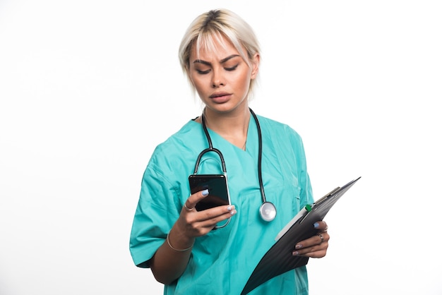 Female doctor making telephone call on white surface